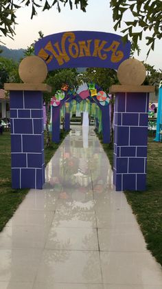 the entrance to an amusement park is decorated in blue and yellow bricks with flowers on each side