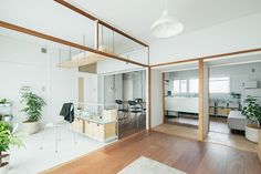 an open living room and dining area with wood floors, white walls and wooden trimmings