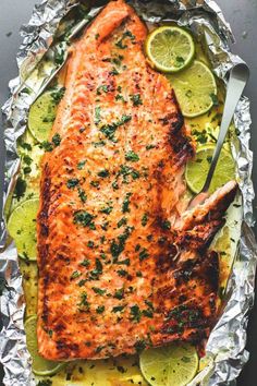 grilled salmon on foil with limes and lemon wedges, ready to be served