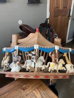 a merry go round with figurines on it in front of a wooden door