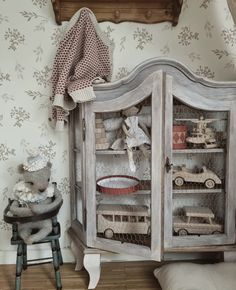 an old china cabinet with toys in it