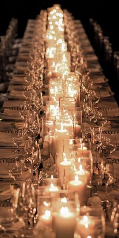 a long table with many lit candles on it