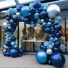 an arch made out of blue and silver balloons