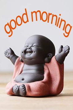 a small buddha statue sitting on top of a wooden table with the words good morning above it