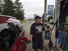 a man filling up his car at a gas station