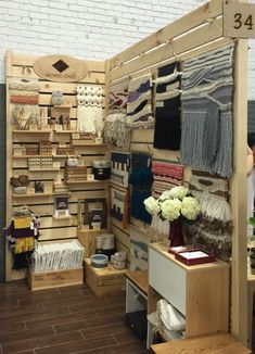 a room filled with lots of different types of clothing and accessories on display in front of a white brick wall