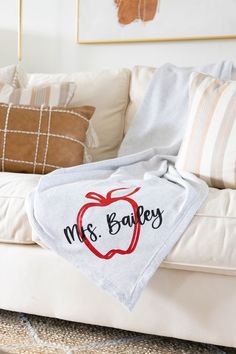 a white couch with a personalized apple on the back and mrs bakes written on it