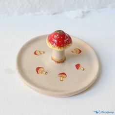 a small red mushroom sitting on top of a white plate