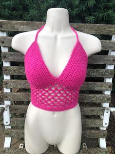 Handmade bright fuscia pink crochet halter crop top with a cute fishnet pattern.  One-of-a-kind freehanded pattern! Very stretchy and adjustable and fits a variety of different sizes and shapes. Also made with thick and sturdy triple back ties and neck ties. Perfect for spring, summer, concerts, raves, festivals or just everyday wear! Photos taken in natural lighting Fitted Pink Crop Top For The Beach, Stretch Pink Crochet Top, Pink Halter Neck Crochet Top For Beach, Stretch Crochet Top In Pink, Pink Stretch Halter Top For Festival, Stretch Pink Halter Top For Festivals, Pink Crochet Halter Top For Spring, Pink Crochet Crop Top For Festival, Pink Crochet Top For Festival