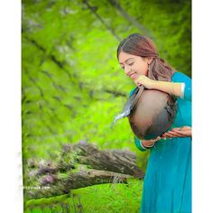 a woman is holding a bird in her hands