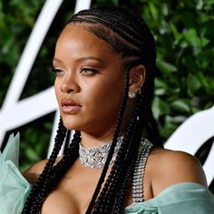 a close up of a person with braids on her head and wearing a blue dress