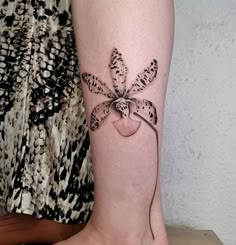 a woman's leg with a tattoo on it and a flower in the shape of a heart