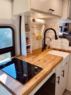 a kitchen with a stove top oven next to a sink and window in the wall