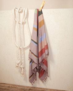 a towel hanging on a wall next to a rope with a hook in the corner