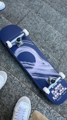 a person standing next to a skateboard on the ground