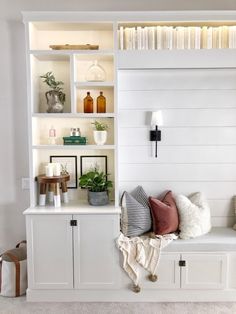 a room with some bookshelves and pillows on top of the shelves in it