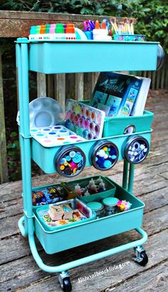 a blue cart filled with lots of items on top of a wooden deck