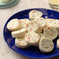 a blue plate topped with rolls on top of a table