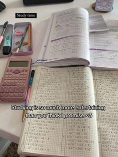 an open book sitting on top of a table next to a calculator and pen