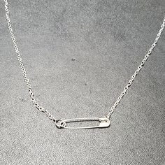 a silver necklace with an arrow on it