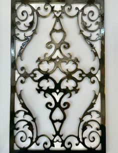 a decorative metal panel with hearts and swirls on it's sides, mounted to the wall