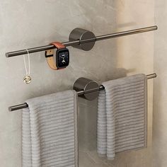 two towels are hanging on the wall next to an apple watch and towel rack in a bathroom