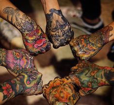 a group of people with tattoos on their hands