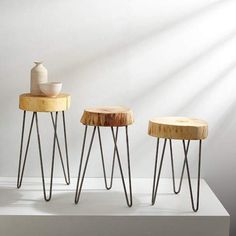 three wooden stools sitting next to each other