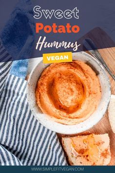 sweet potato hummus in a white bowl on a wooden cutting board next to bread