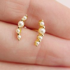 Add a sweet touch to your ear stack with our Pearl Climber Earrings. Choose from gold or silver to effortlessly achieve a delicate look, perfect for everyday wear. Layer them with our pearl huggies for a stylish and versatile option. See the matching pearl huggies here: https://etsy.me/4fsrWY6 DETAILS: - stud back - measures 12mm long - available in gold or silver Materials: - sterling silver or 14kt gold plated over sterling silver - nickel free - synthetic pearls Packaging + Delivery: All items come packaged in a cute Amanda Deer Jewelry box and are sent in a protective bubble mailer. If ordering multiple pieces, please let us know if you'd like separate boxes for each one. If not, we'll include them in one box for you. See all of our listings here: http://www.amandadeer.etsy.com XOXO Th Dainty Tiny Ear Climbers For Everyday, Dainty Ear Climbers For Everyday, Delicate Yellow Gold Ear Climbers For Everyday, Dainty 14k Gold Ear Climbers, Gold Dainty Ear Cuff For Anniversary, Dainty Gold Ear Cuff For Anniversary, Elegant Everyday Ear Cuff, Dainty Yellow Gold Ear Climbers Gift, Dainty Sterling Silver Ear Climbers