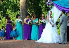 a bride and groom standing in front of their wedding party