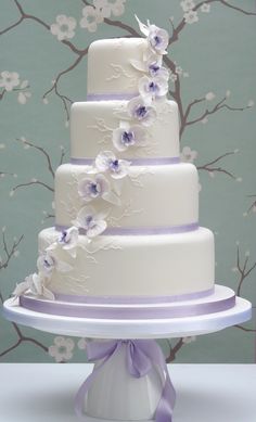 a three tiered white cake with purple flowers on it