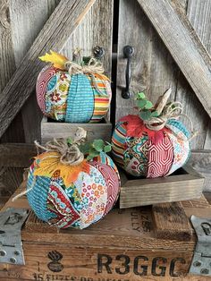 three decorative pumpkins sitting on top of a wooden crate