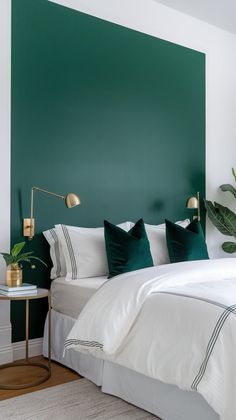 a bed with white sheets and green accenting the headboard, along with two side tables