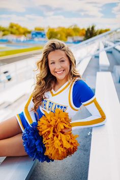 a cheerleader sitting on the bleachers with her pom poms