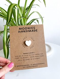 a person holding up a card with a heart on it that says moonies handmade