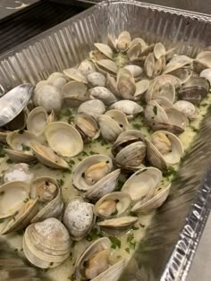 a pan filled with clams on top of a table