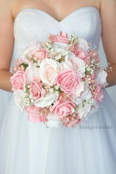 a bride holding a bouquet of pink and white flowers