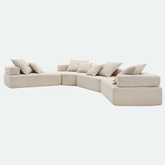 a large sectional couch with pillows on it's back and side facings, sitting in front of a white background