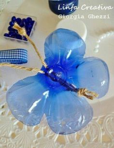 a blue flower sitting on top of a white plate next to other items and decorations