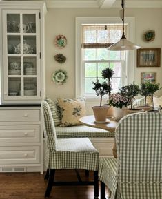 a dining room table and chairs with green gingham checkerboard upholstered seats