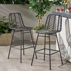 two chairs sitting next to each other near a counter with wine glasses on top of it