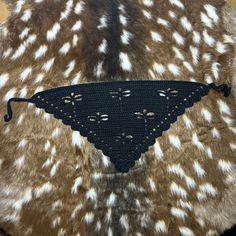 a close up of a brown and white animal fur with a black triangle on it