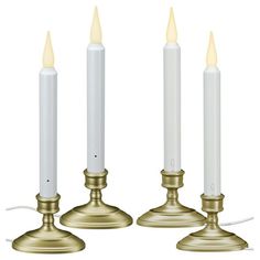 three white candles are lined up next to each other with one candle in the middle