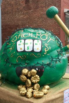 a large green object with gold decorations on it's head and two baseball bats sticking out of the top