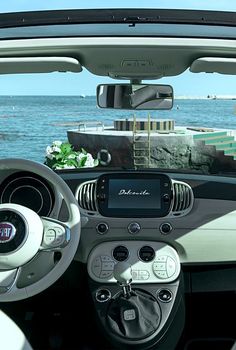 the interior of a small car with an ocean view in the background and text that reads decouvre - la