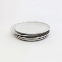 three plates stacked on top of each other in white and grey colors with black rims