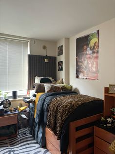 a bed room with a neatly made bed and a painting on the wall above it