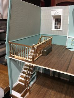 a doll house with stairs and furniture in the room next to it is made out of cardboard