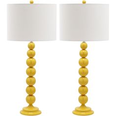 two yellow lamps with white shades on them